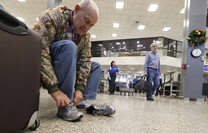 A passenger puts his shoes on after going through security at the Salt Lake City international airport